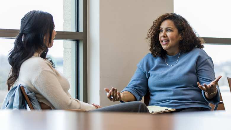 two woman talking at table