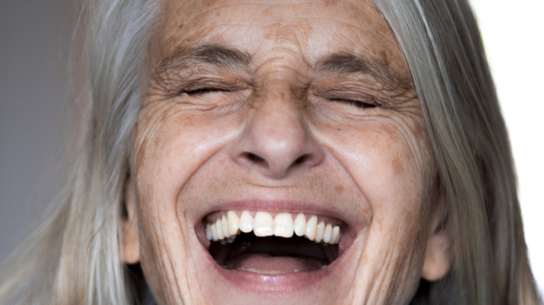 Person with age spots and wrinkles smiling