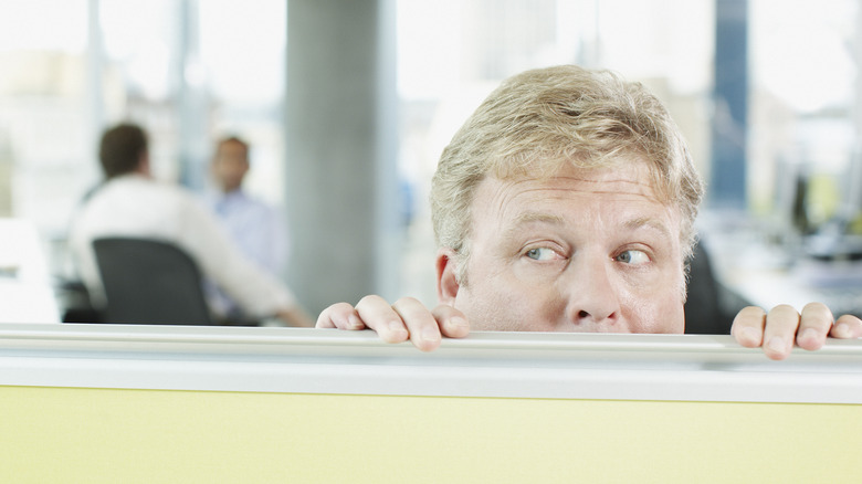 man looking over cubical 