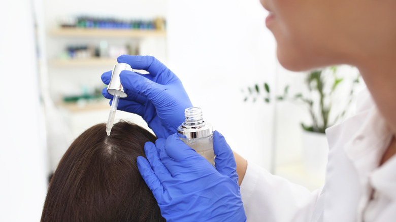 dermatologist applying treatment to scalp