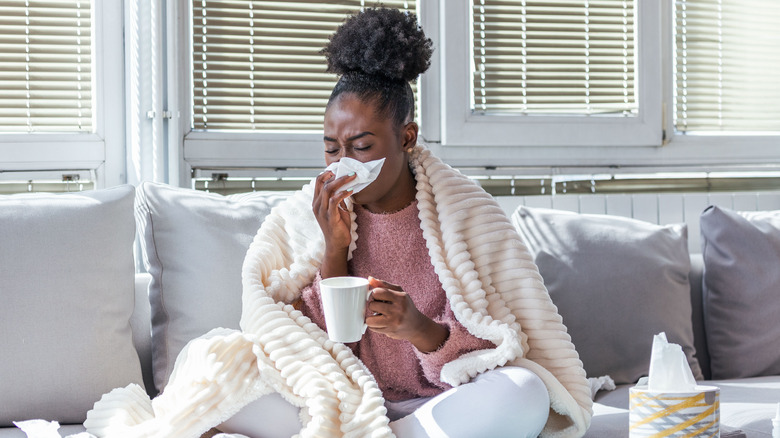 sick woman sitting on couch