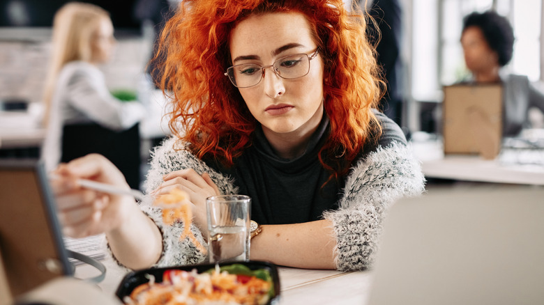 Sad woman eating at restaurant