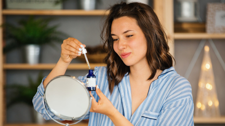 woman holding skincare serum