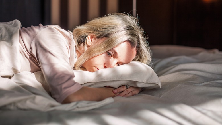 Woman hugging pillow headache