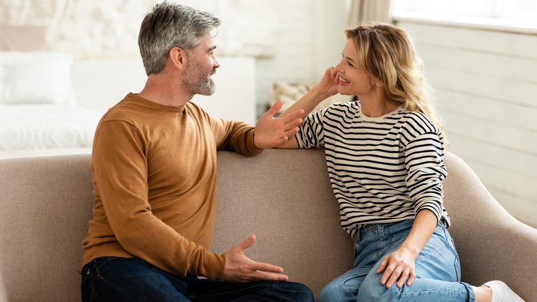 A couple sitting on a couch talking