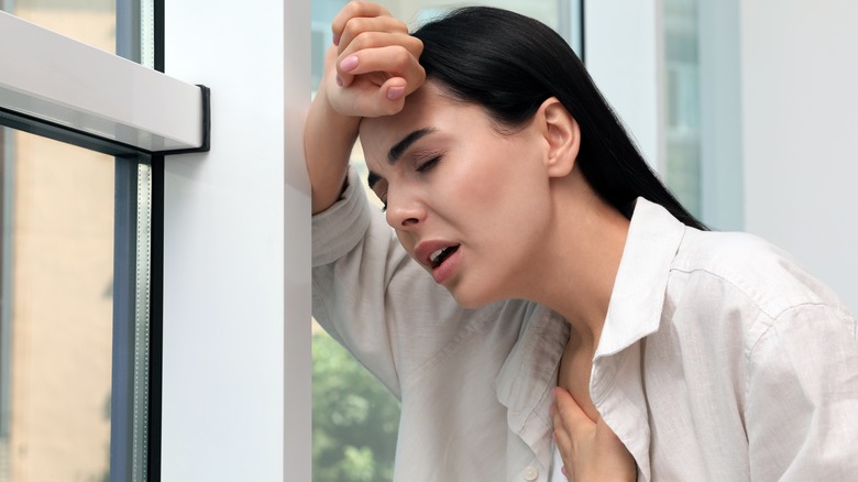 Nervous woman with hand on heart