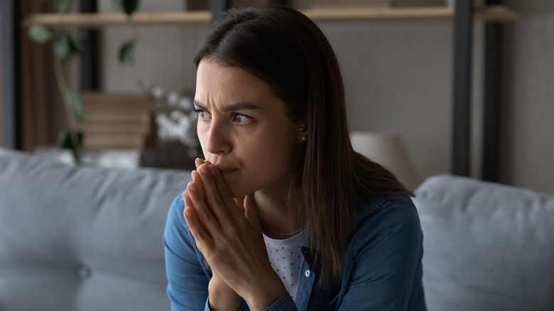 Worried woman with hands clasped