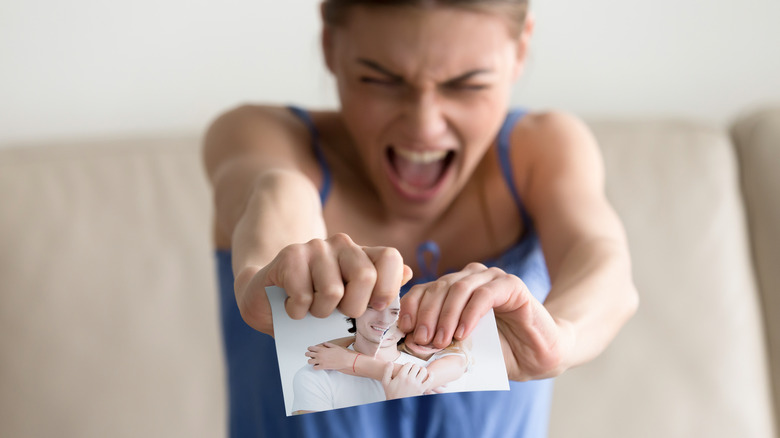 Angry woman ripping a photo in half 