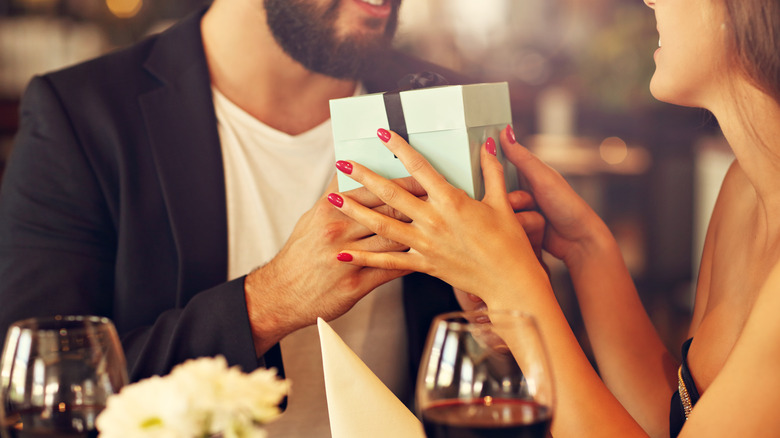 Couple exchanging gifts at a restaurant 