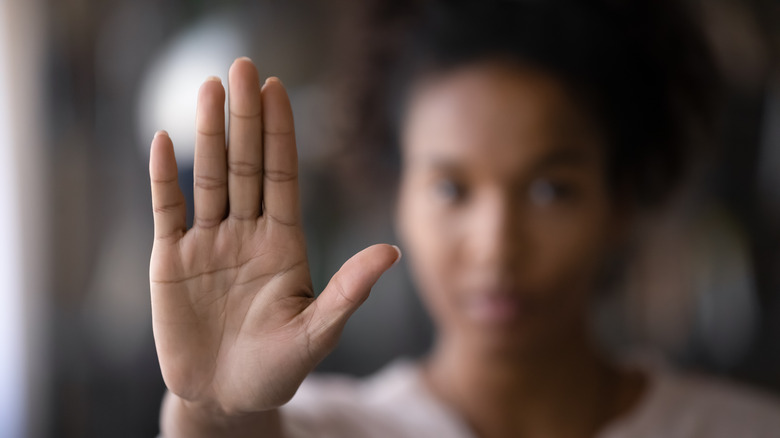 woman holding up flat hand