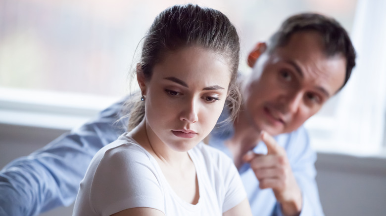 Man pointing at woman's chest