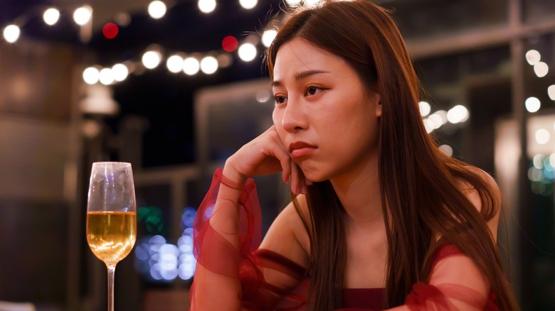 Upset woman alone with wine