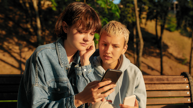 Women looking at smartphones together