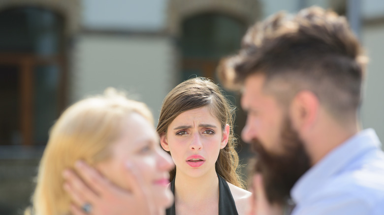 Woman looking at happy couple