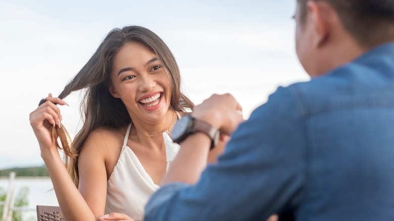 Woman twirling hair during date