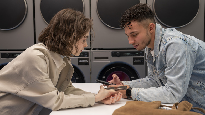 Man and woman leaning toward each other in laundromat