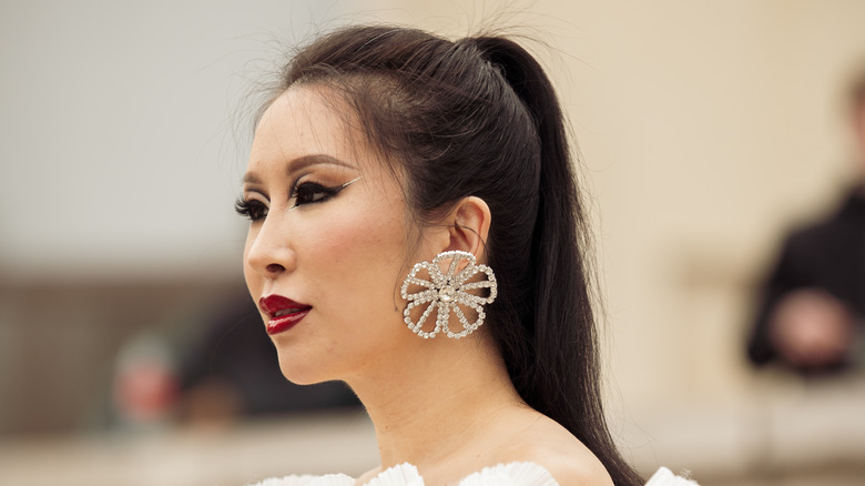woman wearing silver floral earrings