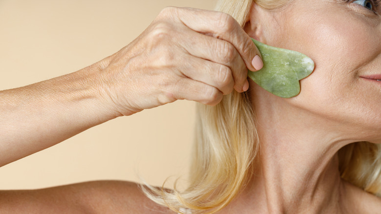 Woman using gua sha tool