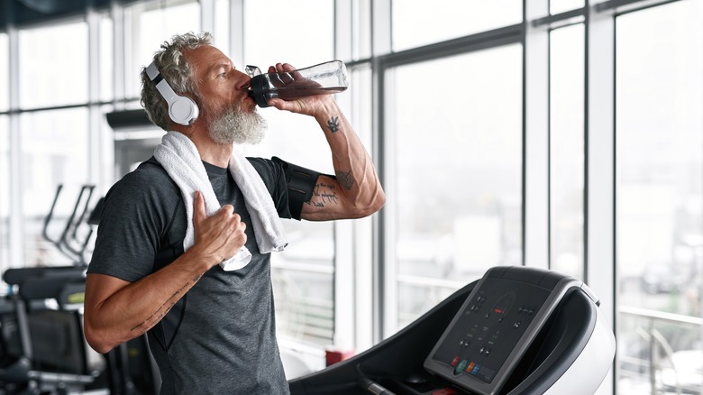 Man drinking water at gym