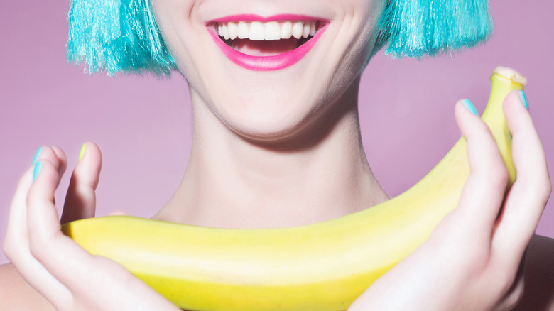Woman with white teeth holding a banana