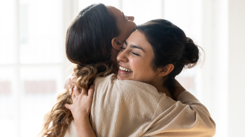 Women embracing and smiling