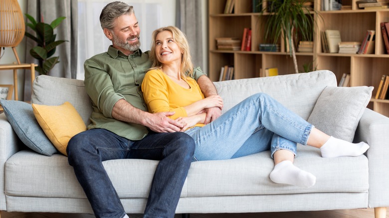 Man snuggling woman on couch