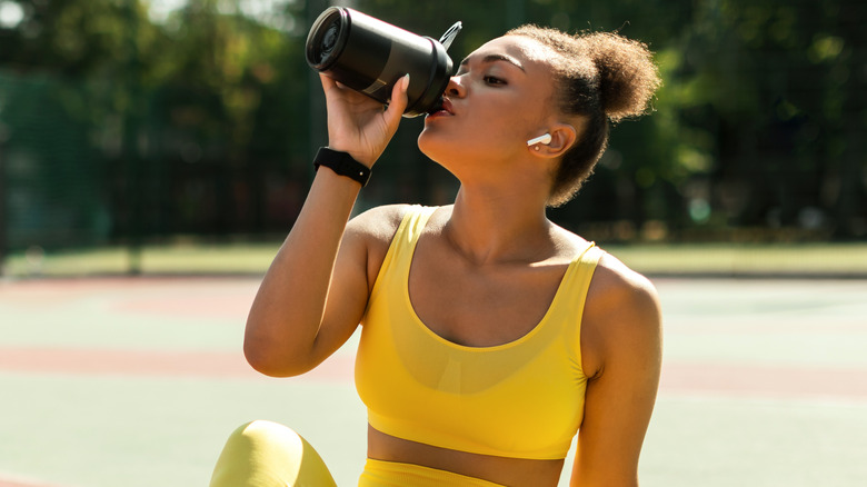 female workout drink water