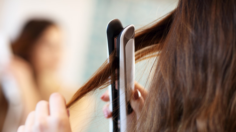 woman straightening hair