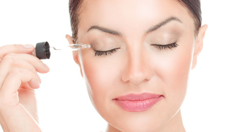 Person using eyelash serum