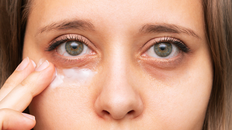 Woman using under-eye cream