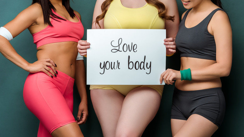 different sized women holding a sign that says "love your body"