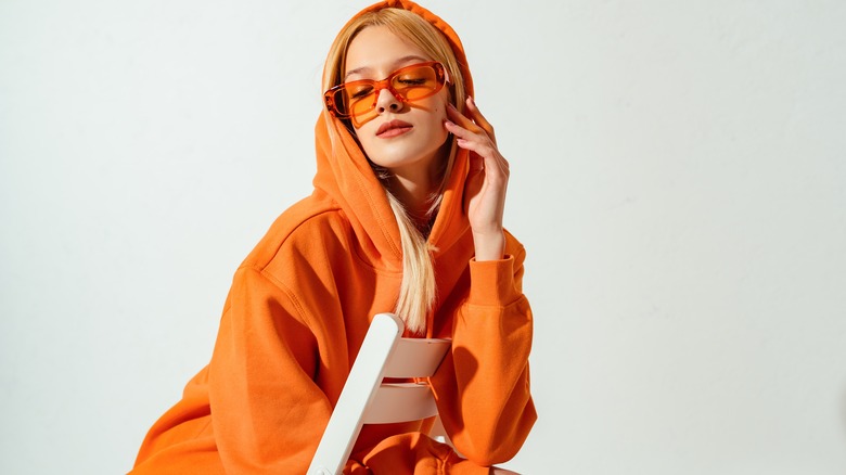 young woman in all orange with shades