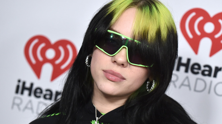 Billie Eilish with green hair and shades