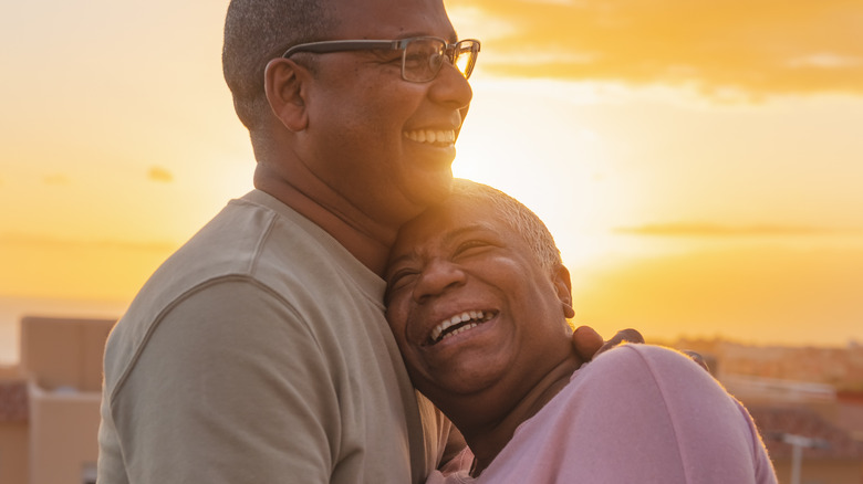 Black couple smiling at sunset