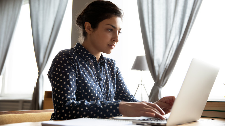 Woman researches on laptop