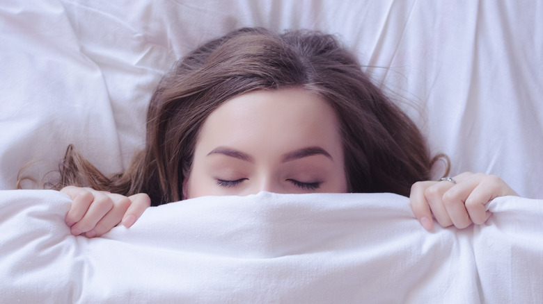 Woman asleep under covers