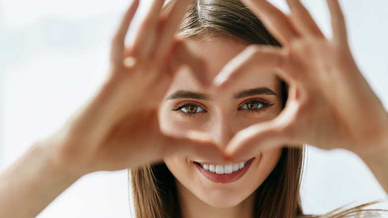 Woman making heart with fingers