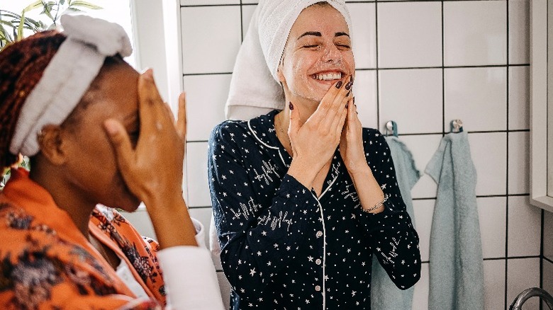 Two women washing their faces