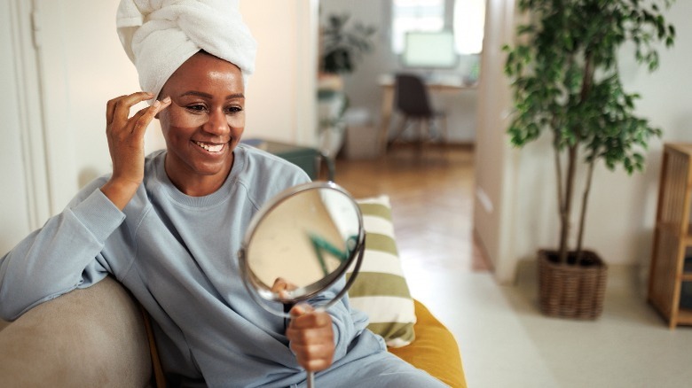 Woman wearing under-eye masks checking herself