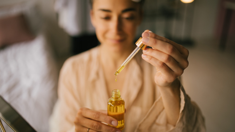 woman using face oil serum