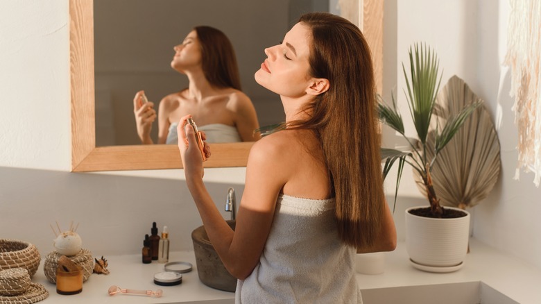 Woman sprays on perfume 