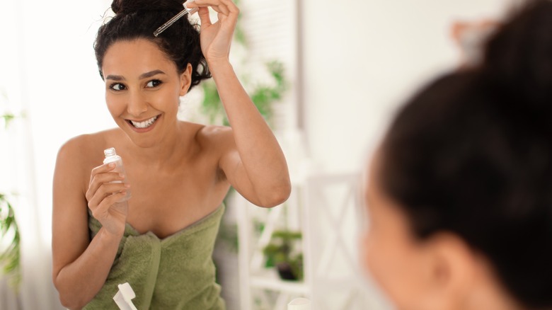 Woman applying bakuchiol to the scalp