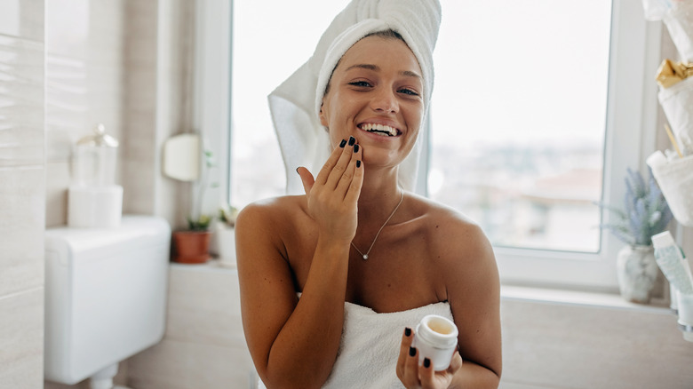 African American Woman putting on face cream