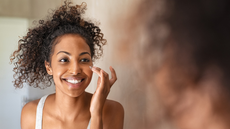 Woman applies face cream