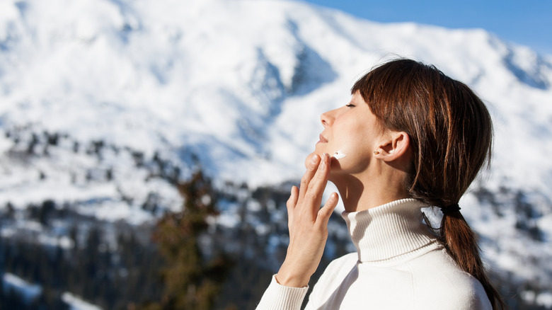 Woman applies sunscreen in the cold