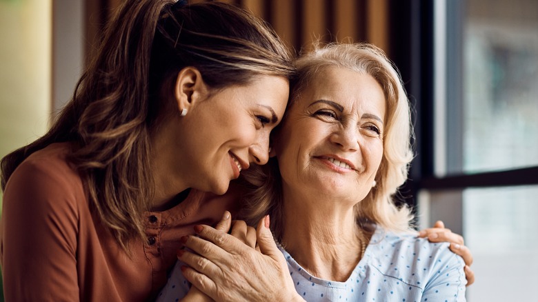 A smiling woman hugging her mother