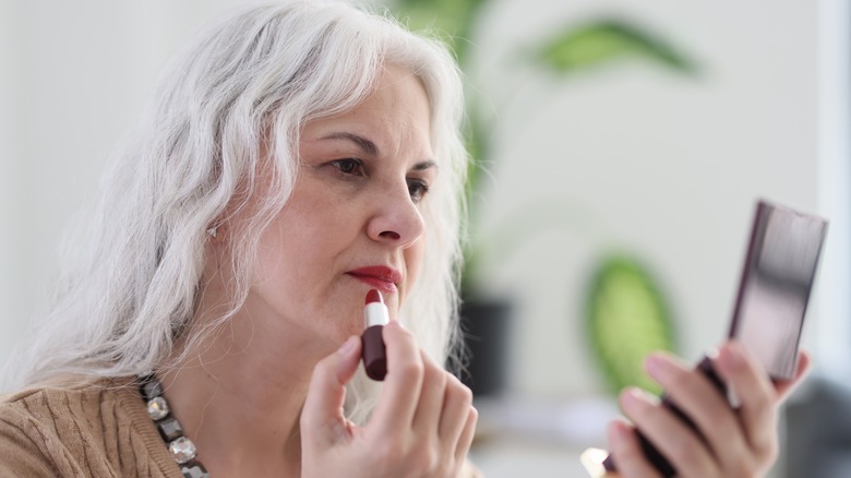 Woman applying red lipstick