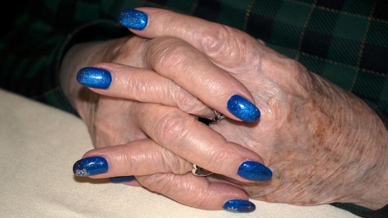 Mature hands with bright blue nail polish