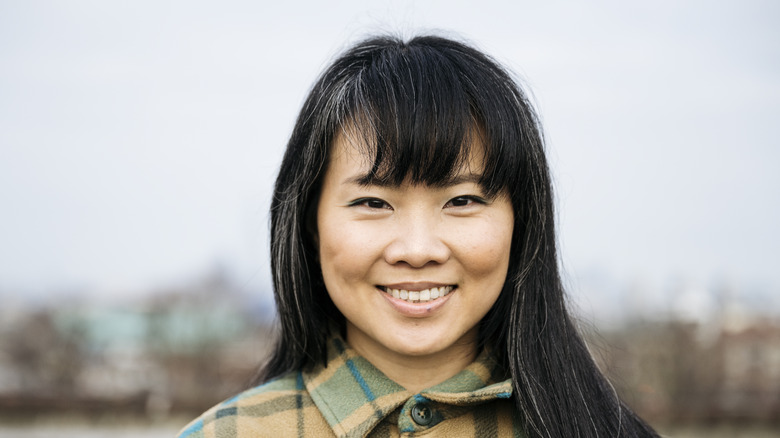 A woman with black hair and thick bangs