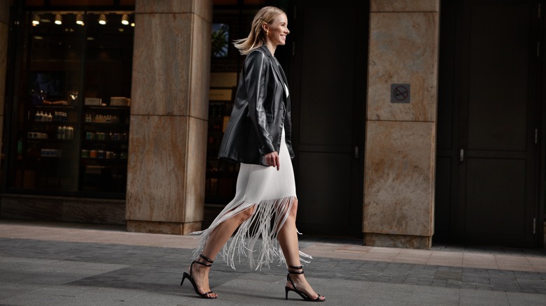 Woman wearing leather jacket fringed skirt